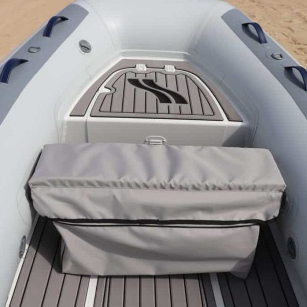 Interior de una lancha inflable con un banco de almacenamiento gris y un fondo de cubierta antideslizante. Ideal para actividades acuáticas y paseos en el mar.